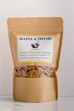 Load image into Gallery viewer, A standing pouch packaging of Maple &amp; Thyme Lemon Pistachio Granola. The package is brown with a clear window showing the granola inside, and the label has the brand and product name.

